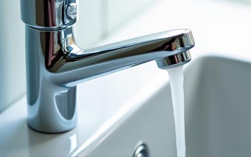 Close-up of a sparkling clean kitchen faucet and sink.